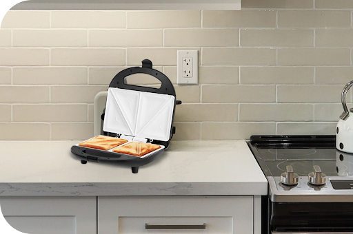 Electric sandwich toaster preparing toasted sandwiches on a modern kitchen countertop